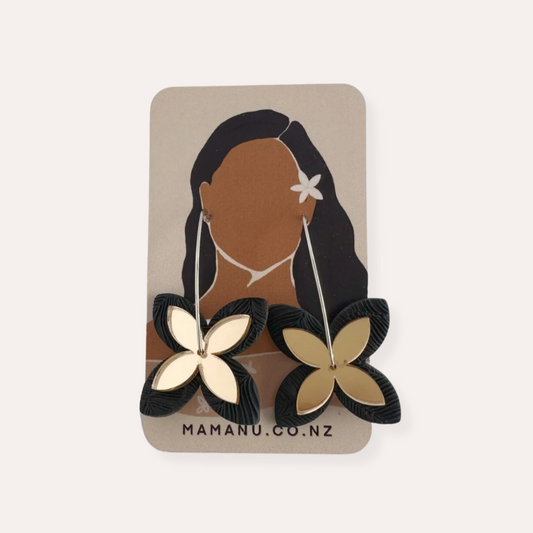 Flower-shaped, Pacific-inspired earrings on a MAMANU.CO.NZ branded card with a Pasifika woman's silhouette.